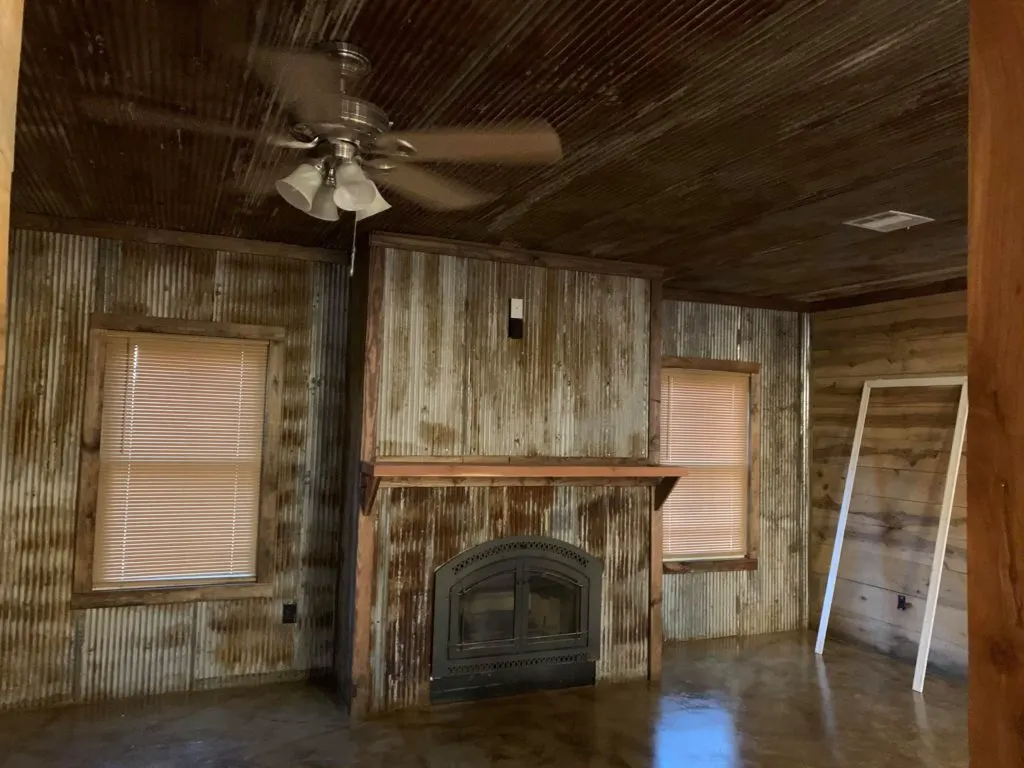 Reclaimed corrugated tins for the ceiling, fireplace, and living room walls