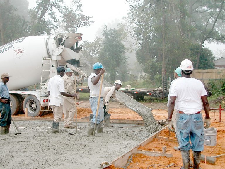 Experienced builders pouring concrete