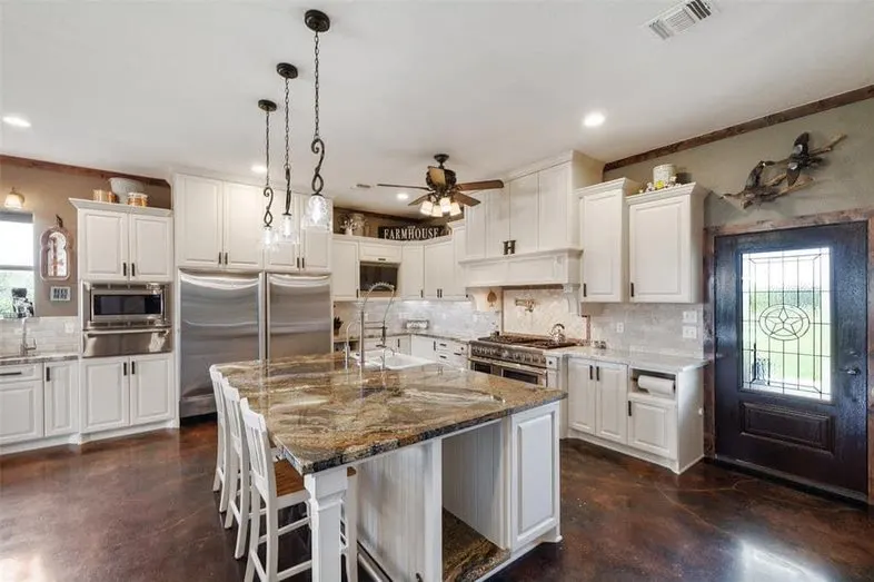 Kitchen with focus on the double gas range and large white farmhouse sink.