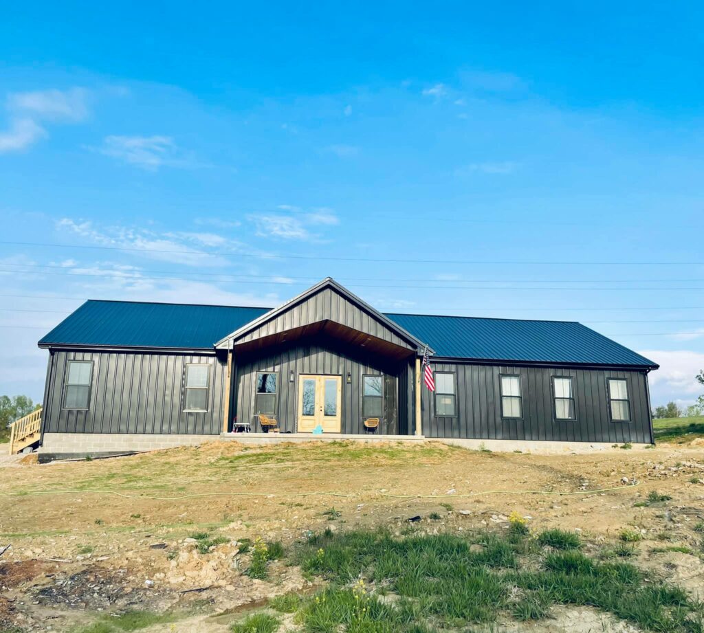 Front Exterior of the home, all black siding, roof and black framed windows.