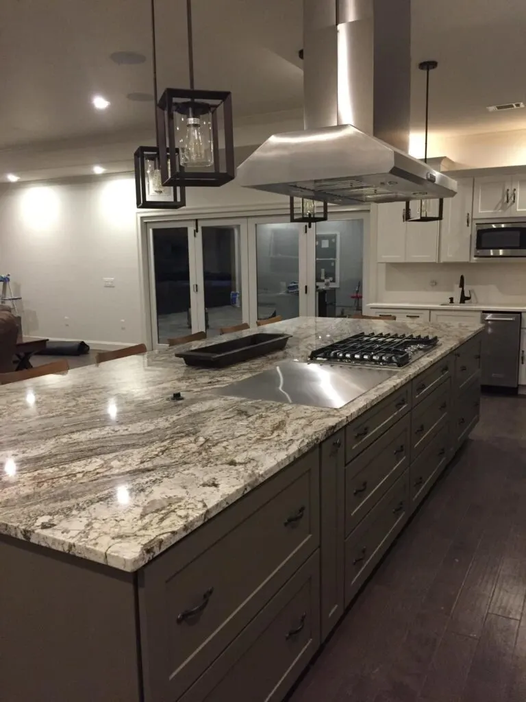 Granite-covered kitchen island with stove-top and grill