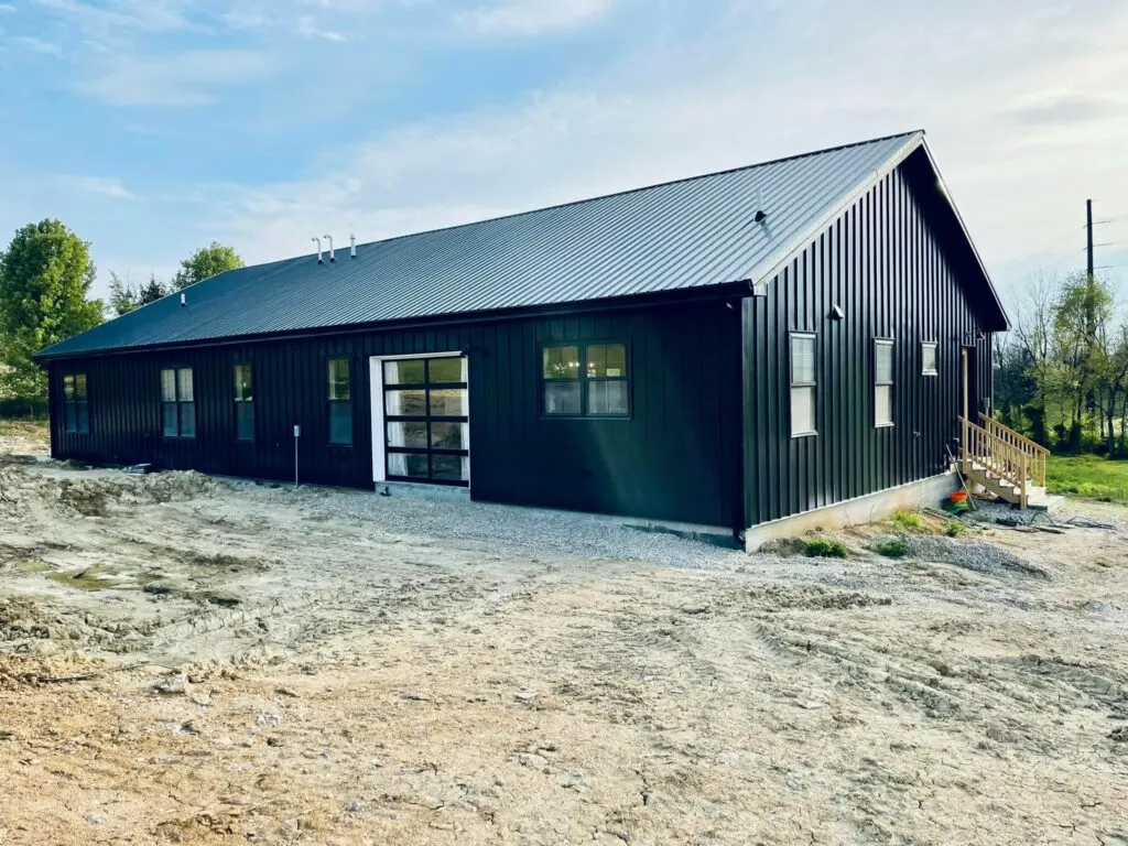 Exterior image of the back of the home with a glass garage style door.