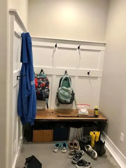 Mudroom with hall tree featuring hooks and a bench. 
