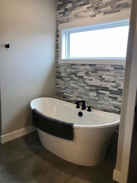 Free standing tub with stone accent wall