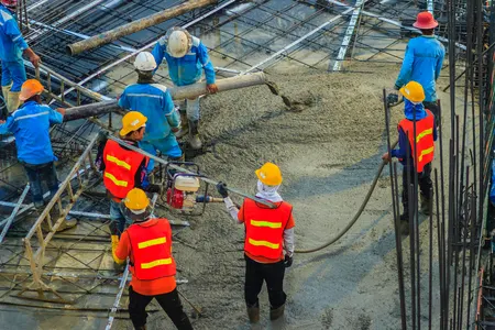 Construction workers pouring concrete foundation