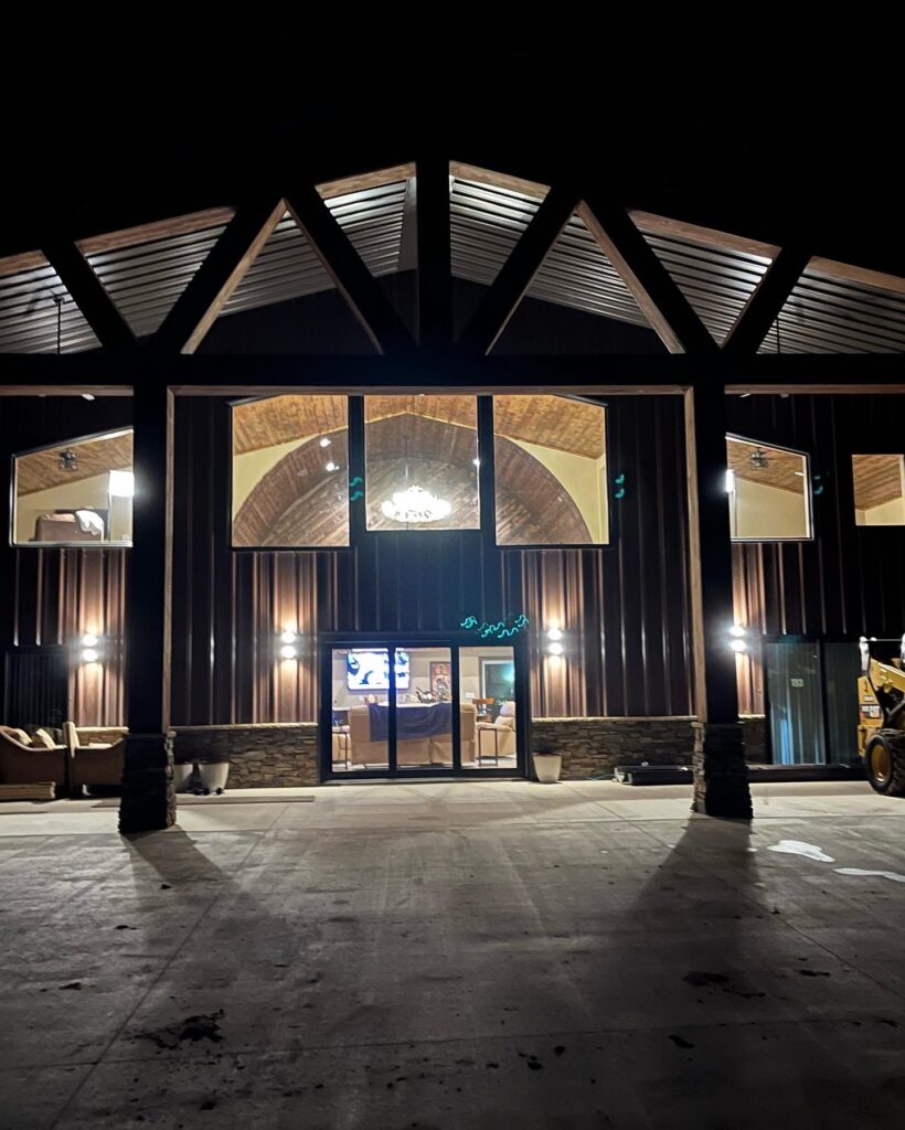 A shot at night showing Whiskey Barrel Ranch Barndominium from the outside.